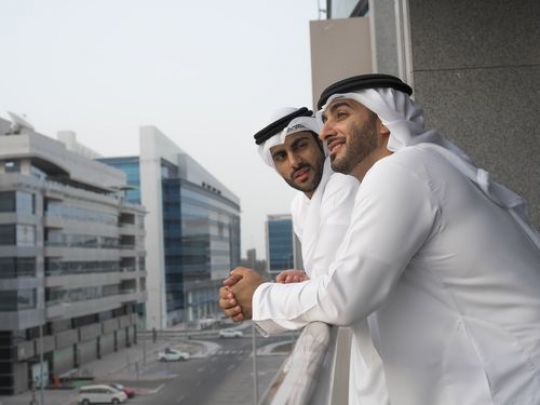Two arab men standing outside at the balcony|-