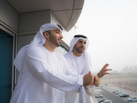 Two businessmen standing outside at the balcony