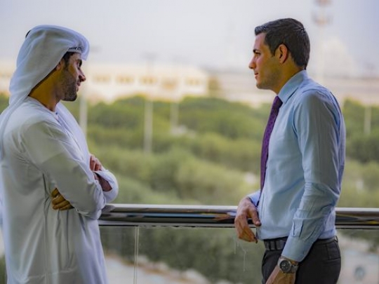 Two businessmen having a conversation at the balcony|