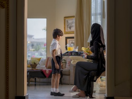 Arab mother preparing her sons lunch box|-