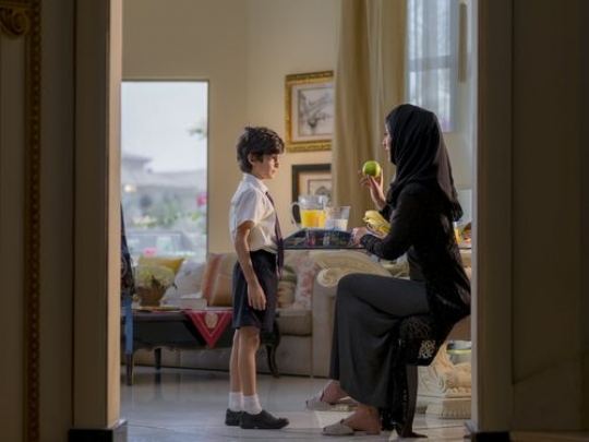 Arab mother preparing her sons lunch box for school|-