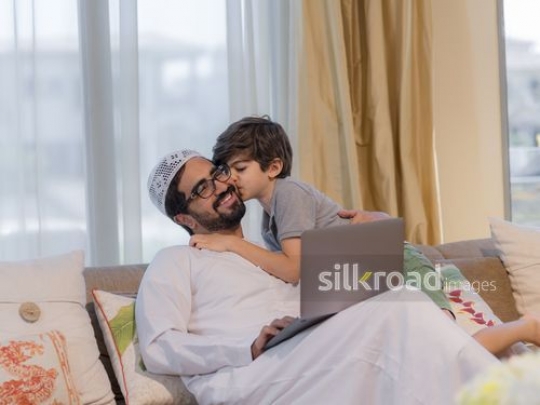 Young Arab boy kissing the arab man on his cheek|