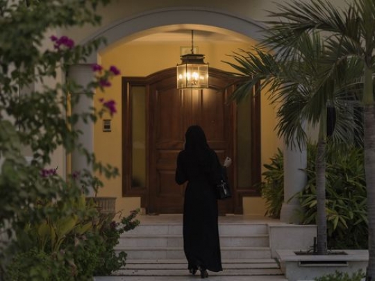 Arab woman walking towards her house|-