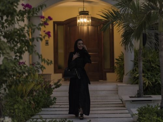 Arab woman walking while talking on the phone|-
