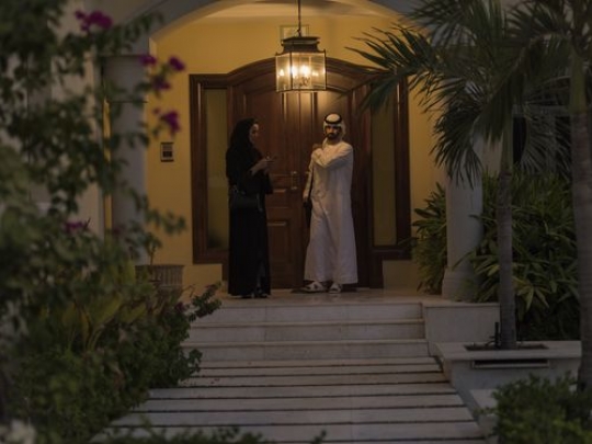 Arab mn and woman standing outside the house|-