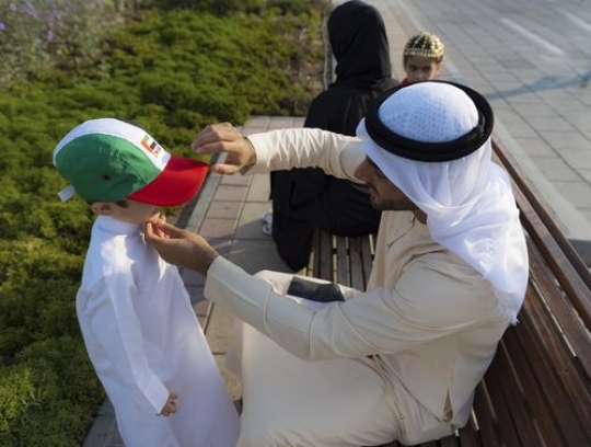 Side view of father fixing his child hat while the mother and the daughter are next to them|-