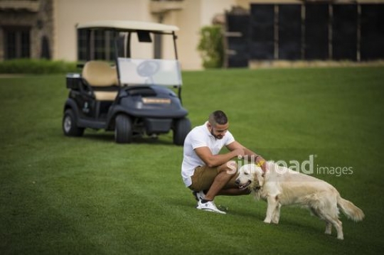 Middle Eastern man petting the dog |-