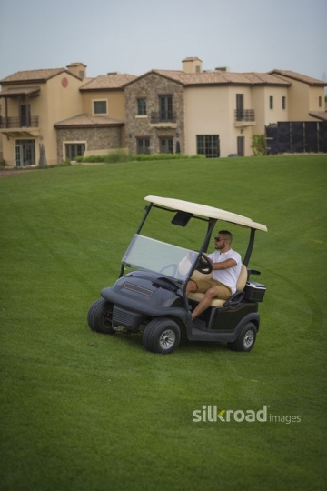 Middle Eastern man driving around with the Golf Cart|-