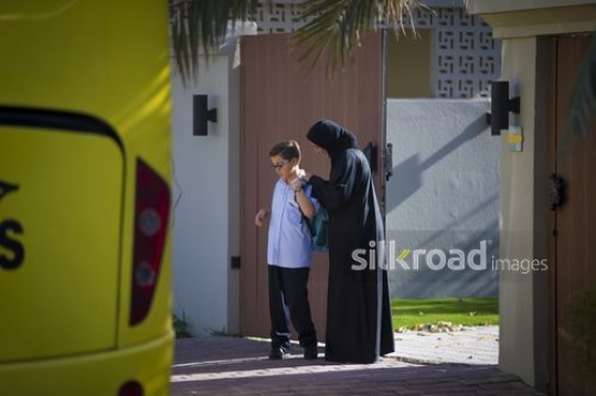 Middle Eastern mother dropping her kid to the school bus|-