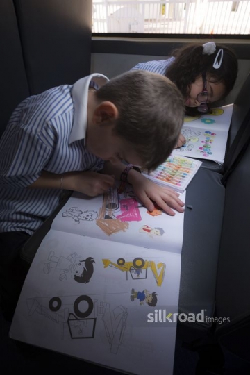 Arab kids sitting on the school bus coloring |-
