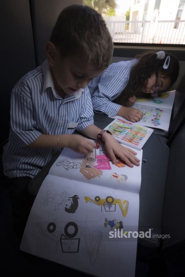 Students sitting on the bus colouring |-