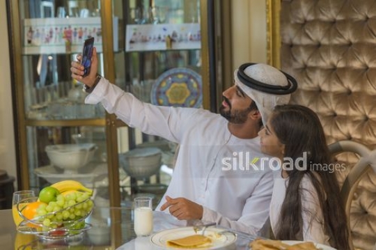 Middle Eastern father taking a selfie with his daughter|