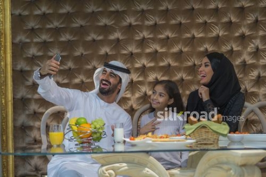 Middle Eastern family sitting together taking a selfie|
