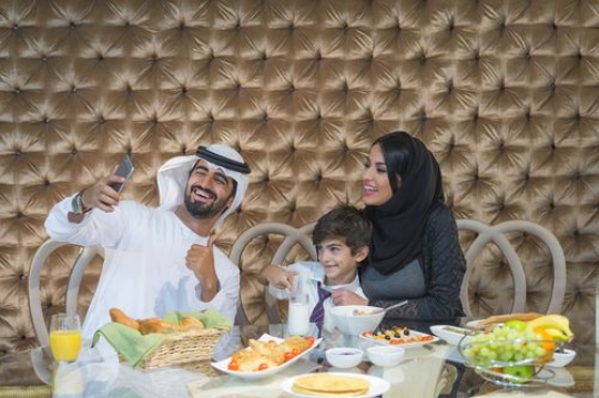 Arab father taking a photo with his wife and son|-