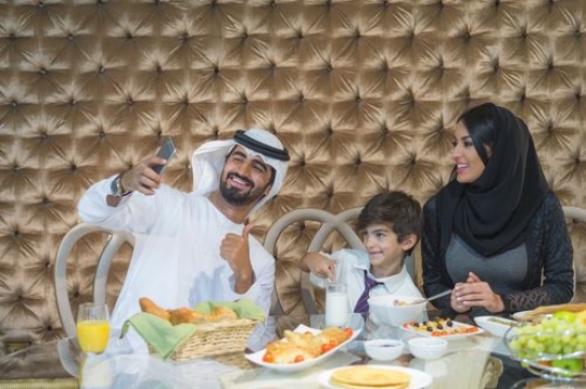 Arab family taking a photo during breakfast|-