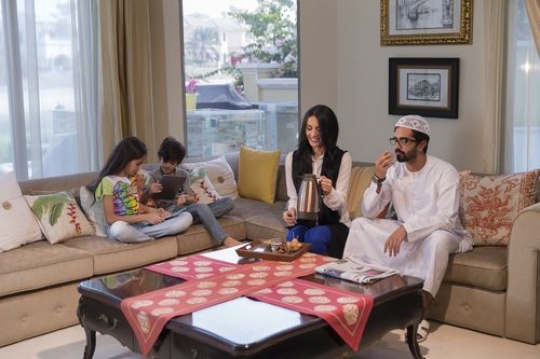 Arab parents sitting together while the kids are on their devices|-