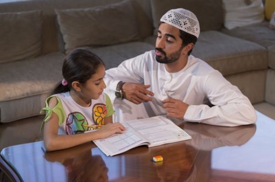 Arab man and daughter studying|-
