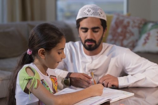 Arab man and daughter studying|-