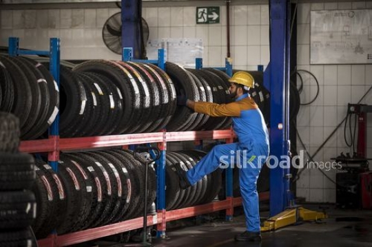Car Mechanic pulling out a tire