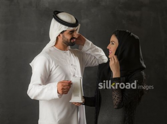 Middle Eastern woman holding an incense burner talking to the Middle Eastern man|