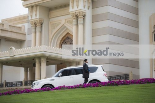 Middle Eastern Businessman walking next to the car|