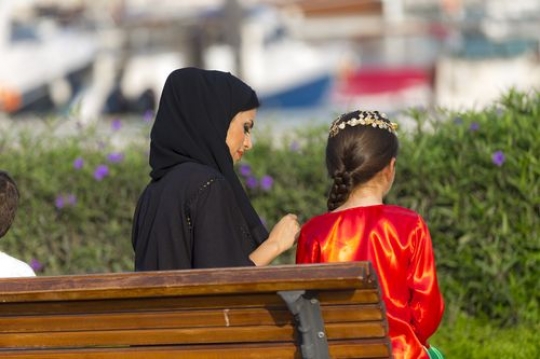 Mother and daughter sitting on the bench and spending time with each other|-