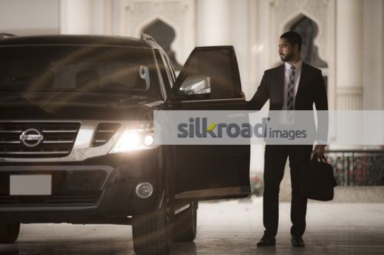 Arab Businessman standing by the car|