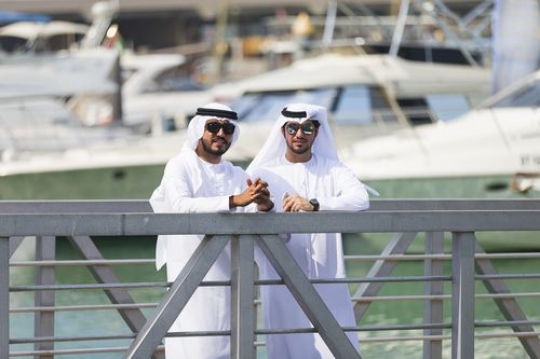 Middle eastern men standing by the dock|