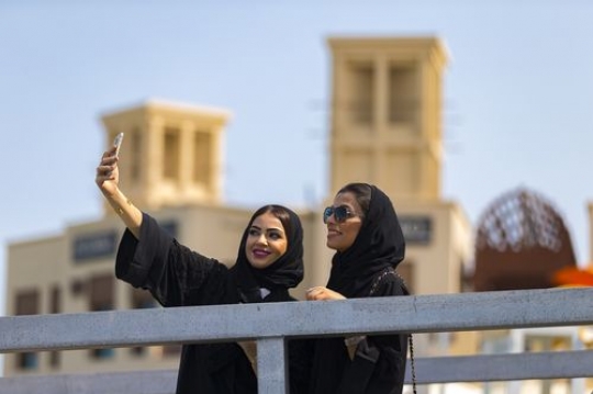 Women standing by the dock taking a picture together|