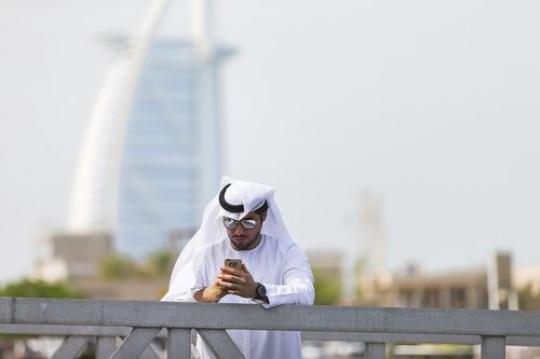 Man dressed in the traditional attire standing by the dock |