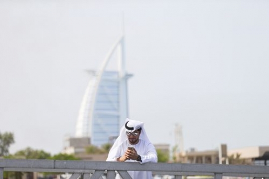 Arab man standing by the dock with a background of a famous landmark|
