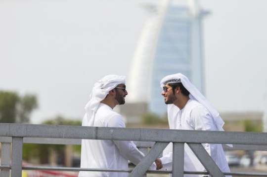 Arab men standing by the dock greeting each other|