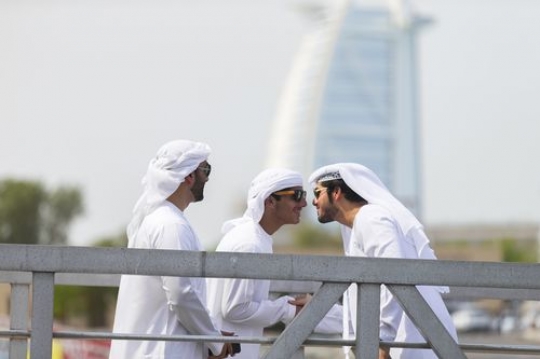 Arab man greeting another man while standing on the dock|