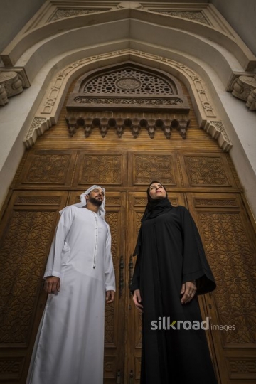Middle Eastern Businessman and Businesswoman standing infront of a gate|-