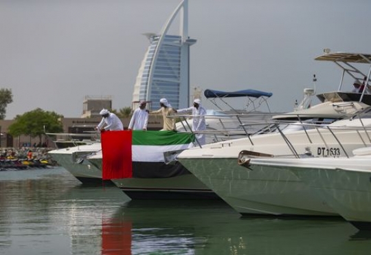 Arab men standing on the yacht celebrating National Day|