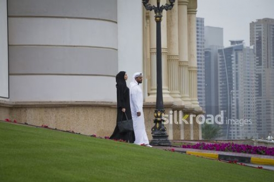 Middle Eastern Businesswoman and Businessman walking outside|-