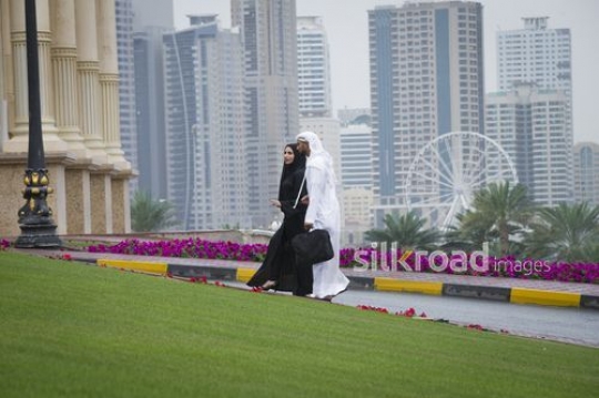 Middle Eastern business man and business woman walking together|-
