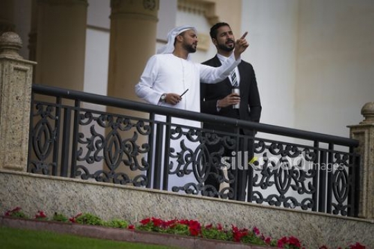 Middle Eastern business man pointing and talking to his colleague|-
