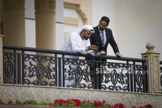 Middle Eastern businessmen talking to each other|-