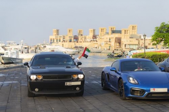 Middle eastern men driving their cars during a National Day Parade|-