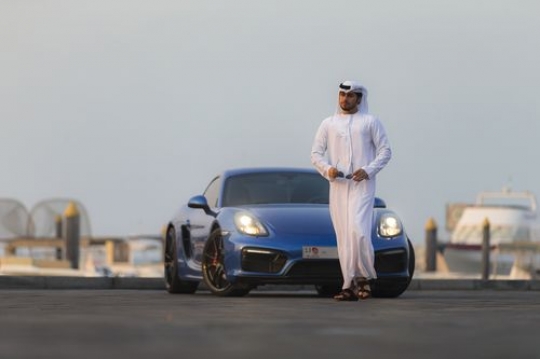 Arab man in motion walking away from his blue vehicle|-