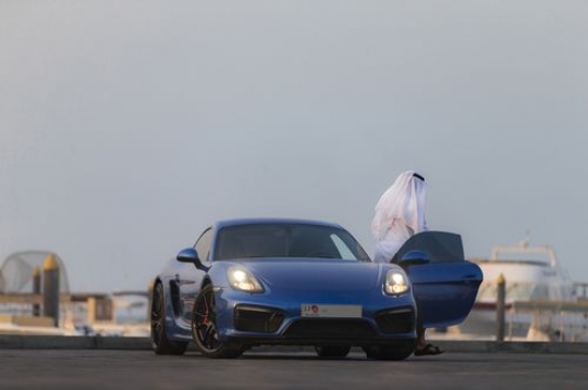 Arab man dressed in traditional attire exiting the luxury car|-