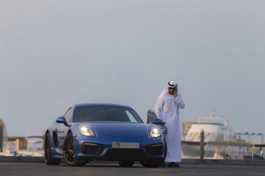 Arab man closing the car door while talking on the phone|-
