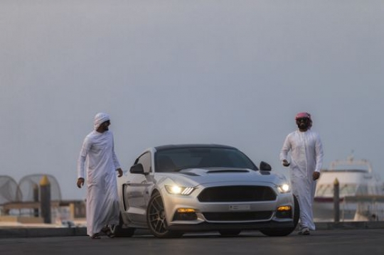 Middle eastern men dressed in traditional attire walking away from the vehicle|-