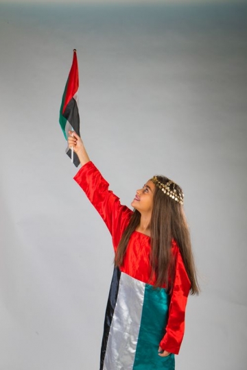 Emirati Girl raising the UAE Flag