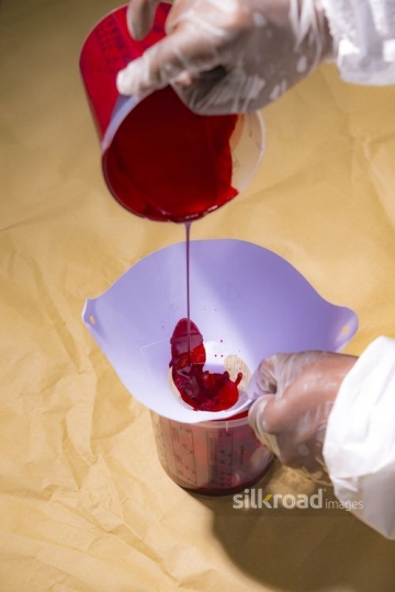 Man pouring Red Paint in the cup |-