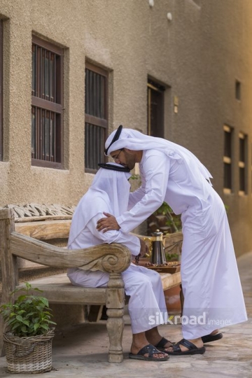 Arab son showing respect to his father|-