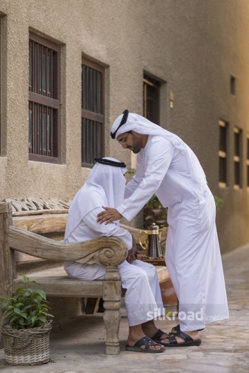 Arab son showing respect to his father|-