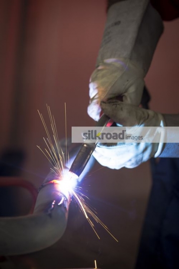 Engineer using machine to cut through metal|