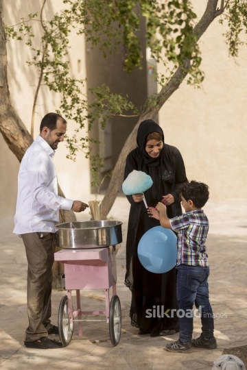 Arab mother and kid getting cotton candy|-